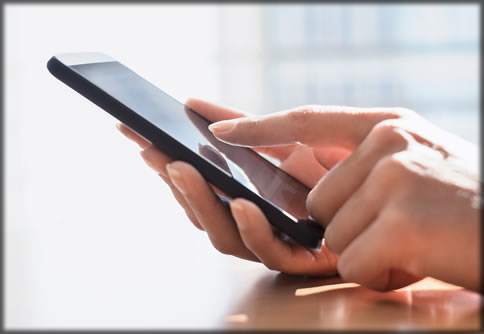 Close up of two hands using a cell phone.