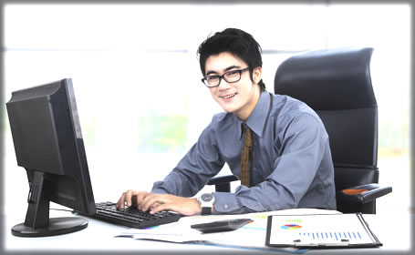 A young man working at office while typing on a keyboard