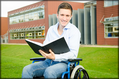 A man in a wheelchair in front of a University.