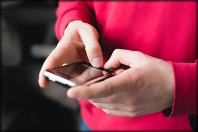 Close up of a man's hands holding a cellphone.