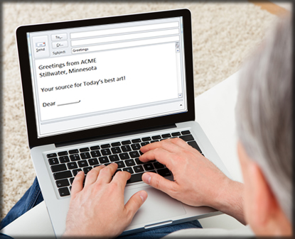 A man typing an email on a laptop.