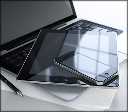 Laptop with tablet and cell phone on top of it.