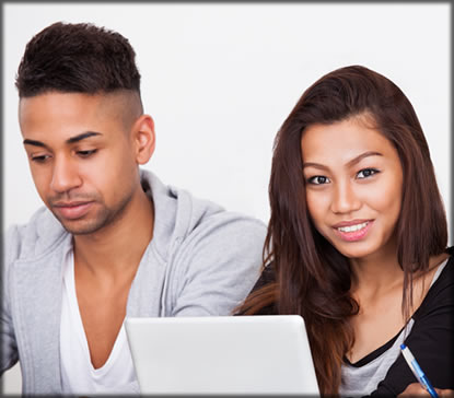 Man and a woman sitting by a laptop.