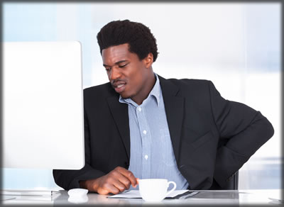 Man in a business coat sitting at a computer.