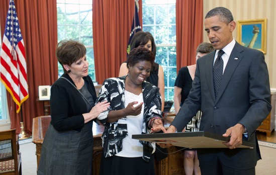 President Barack Obama looks at a painting presented to him by artist Lois Curtis