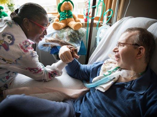 Personal-care attendant Nora Clark playfully arm-wrestled Scott Semo after helping him eat, exercise and finish other tasks.