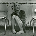 Seated on floor by radiator